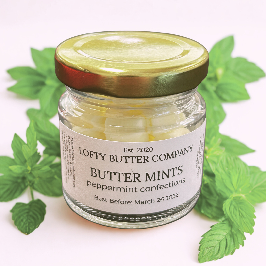 Jar of Lofty Butter Company Butter Mints with peppermint leaves on a white background